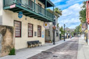 a street with a building with a balcony and a bench at 15 Hypolita in St. Augustine