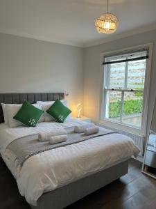ein Schlafzimmer mit einem großen Bett mit grünen Kissen in der Unterkunft Ground Floor Flat BishopAuckland in Bishop Auckland