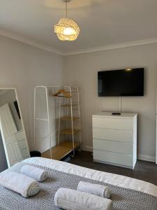 ein Schlafzimmer mit einem Bett und einem Fernseher an der Wand in der Unterkunft Ground Floor Flat BishopAuckland in Bishop Auckland