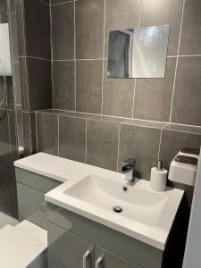 ein Badezimmer mit einem weißen Waschbecken und einem Spiegel in der Unterkunft Ground Floor Flat BishopAuckland in Bishop Auckland