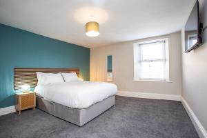 une chambre avec un grand lit et un mur bleu dans l'établissement Livingston Retreat 4bed Home Wi-Fi Parking, à Uphall