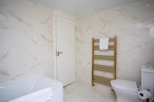 une salle de bains blanche avec toilettes et lavabo dans l'établissement Livingston Retreat 4bed Home Wi-Fi Parking, à Uphall