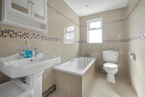 a white bathroom with a sink and a toilet at Contractors - Businesses - Families - Long term Stays - Free parking in Thornton Heath