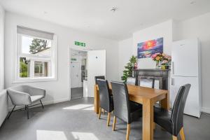 a dining room with a wooden table and black chairs at Contractors - Businesses - Families - Long term Stays - Free parking in Thornton Heath