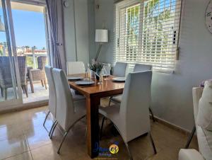 a dining room with a wooden table and white chairs at Los Dolses Family Villa with Private Pool LD07 in Los Dolses