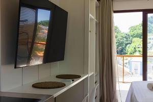a kitchen with a counter with a tv on the wall at MAR DÁ LIBERDADE com Amerigo 122 in Cairu