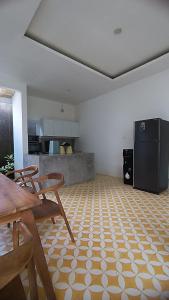 eine Küche mit Tisch und Stühlen und einem Kühlschrank in der Unterkunft D'Villa in Uluwatu