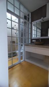 ein Badezimmer mit Dusche und Waschbecken und einem Fenster in der Unterkunft D'Villa in Uluwatu