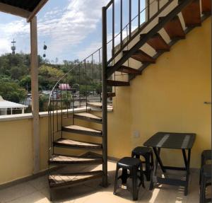 a staircase on a balcony with a table and stools at Pousada MC in Aparecida
