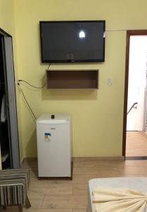 a living room with a flat screen tv on the wall at Pousada MC in Aparecida