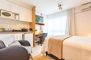 a bedroom with a bed and a desk and a kitchen at Flat melhor localização Brasilia Biarritz Long Stay in Brasilia