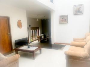 Una sala de estar con un sofá y una mesa de café. en Mervins & Indus Residence, en Nugegoda