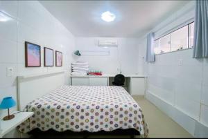 una camera da letto bianca con un letto e una finestra di cód 164 - Casa de Praia com Piscina a Governador Celso Ramos