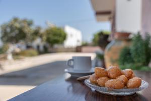 a plate of donuts on a table with a cup of coffee at Frantzis studio 3 Nisyros in Páloi +20 photos