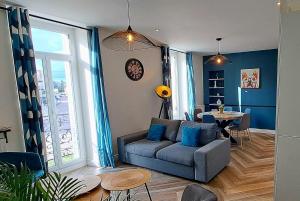 una sala de estar con un sofá y una mesa en L'indigo, 4-6 pers, 2ch-2sdb, proche cité de la gastronomie, en Dijon