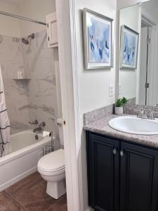 Un baño con lavabo, inodoro y bañera. en Luxury Condo in the Heart of BR, en Baton Rouge