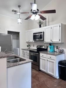 cocina con armarios blancos y ventilador de techo en Luxury Condo in the Heart of BR, en Baton Rouge