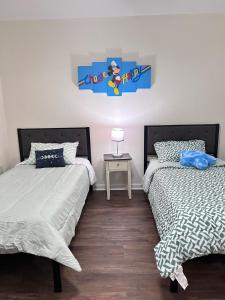 een slaapkamer met twee bedden en een tafel met een lamp bij Luxury Condo in the Heart of BR in Baton Rouge