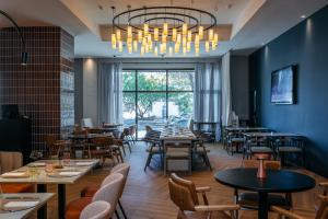 a restaurant with tables and chairs and a chandelier at Rafaelhoteles Atocha in Madrid
