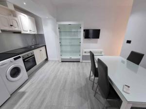 a kitchen with a table and a washing machine at Acc Vergara Parking cercano in Jaén
