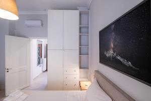 a bedroom with a large flat screen tv on a wall at White & Stars in Athens