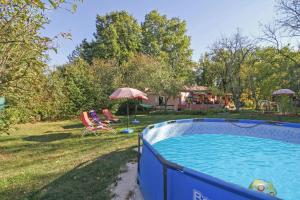 a pool in a yard with two chairs and an umbrella at Antica in Jakačići - Haus für 2-3 Personen in Gračišće
