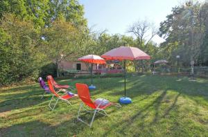 two chairs and two umbrellas in a yard at Antica in Jakačići - Haus für 2-3 Personen in Gračišće