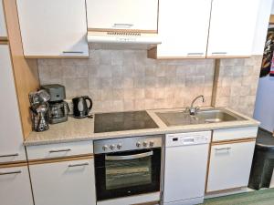 une cuisine avec une cuisinière et un évier dans l'établissement Apartment Wiesenhof-2 by Interhome, à Längenfeld
