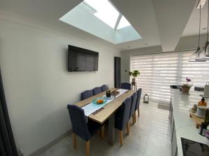 une salle à manger avec une table et des chaises bleues dans l'établissement Modern home in Cardiff City Centre, à Cardiff