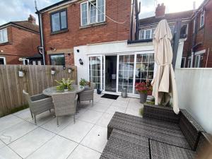 un patio avec une table, des chaises et un parasol dans l'établissement Modern home in Cardiff City Centre, à Cardiff