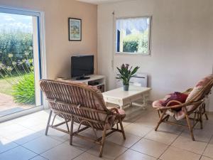 Una sala de estar con dos sillas y un televisor. en Holiday Home L'appel du Large by Interhome, en Kerlouan