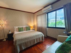 une chambre avec un lit, une fenêtre et un canapé dans l'établissement Lost and Found Hideaway, à Bangkok