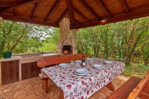 a table and a fireplace in a pavilion with a table and chairs at Villa Theresa in Ližnjan (Haus für 12 Personen) in Ližnjan