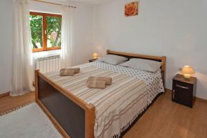 a bedroom with a large bed with two pillows on it at Dea in Kmeti (Haus für 6 Personen) in Žminj +22 photos