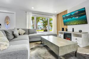 a living room with a couch and a coffee table at Modern 3BR Pool Home with Game Room near Beaches! in Fort Lauderdale