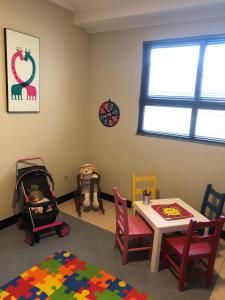 ein Zimmer mit einem Tisch und einem Baby im Kinderwagen in der Unterkunft Golfinhos Apart hotel - apto térreo na praia com café da manhã! in Florianópolis + 33 Fotos