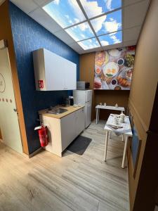 a kitchen with a sink and a table in a room at Elco Rooms Malpensa in Lonate Pozzolo