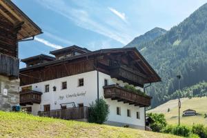 a building with wooden balconies on top of a hill at Unterlacherhof Ahrntal in San Giacomo