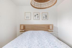 ein Schlafzimmer mit einem Bett und drei Bildern an der Wand in der Unterkunft T3 Les Anémones à 50m de la plage avec grande terrasse et grand jardin in Soorts-Hossegor