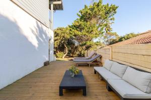 eine Terrasse mit einem Sofa und einem Couchtisch in der Unterkunft T3 Les Anémones à 50m de la plage avec grande terrasse et grand jardin in Soorts-Hossegor
