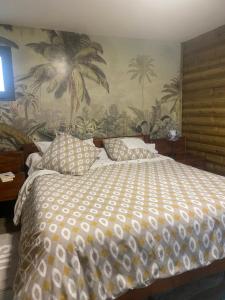 a bedroom with a large bed with a tropical wallpaper at COEUR CREOLE in Le Tampon