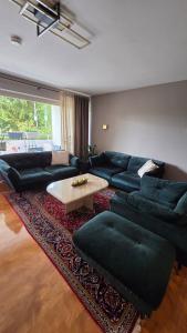 a living room with a couch and a coffee table at Apartment am Waldrand mit Einzelgarage, Nähe City, Messe & Flughafen in Leinfelden-Echterdingen