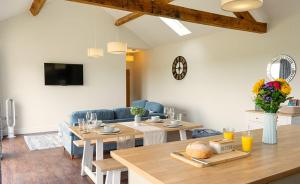 a living room with a table and a dining room at Cornflower in Edlington