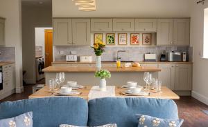 a kitchen with a table and blue chairs in a kitchen at Cornflower in Edlington