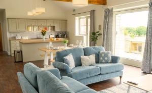 a living room with a blue couch and a kitchen at Cornflower in Edlington