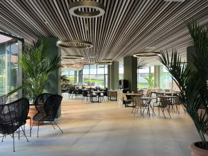 a dining room with tables and chairs and plants at Hotel BCL Podium La Nucia in La Nucía