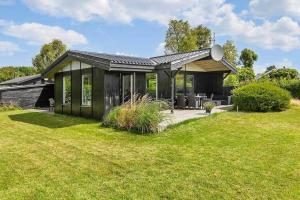 a small black house with a grass yard at SB116-Sydals-Birkemose-29 in Skovbyballe