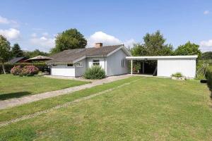 una pequeña casa blanca con un gran patio en SB126-Sydals-Egemose-51, en Skovbyballe