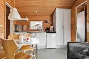 Una cocina con gabinetes blancos y una mesa y sillas. en 3715-Nexo-Klynevej-42, en Snogebæk