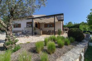 a house with a patio and a tree at Bella Collina in Krajcar Brijeg - Haus für 4-5 Personen in Žminj